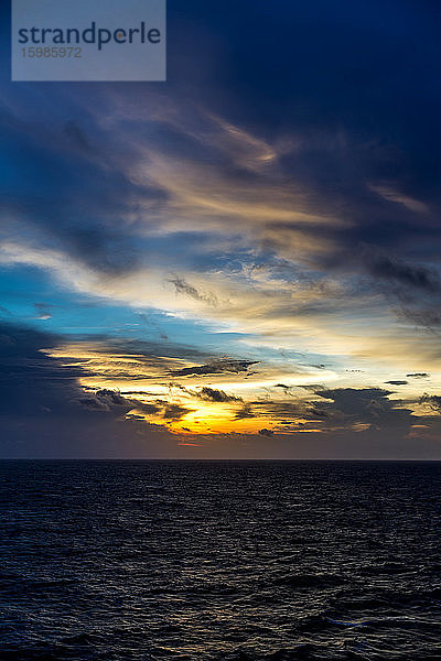 Madagaskar,  Indischer Ozean bei bewölktem Sonnenuntergang