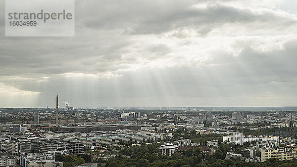 Sonnenstrahlen in Wolken über dem Berliner Stadtbild,  Deutschland