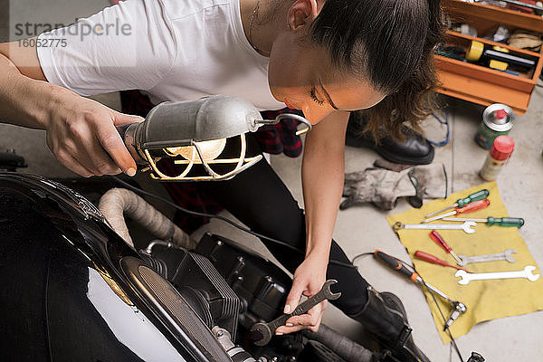 Frau repariert Motorrad