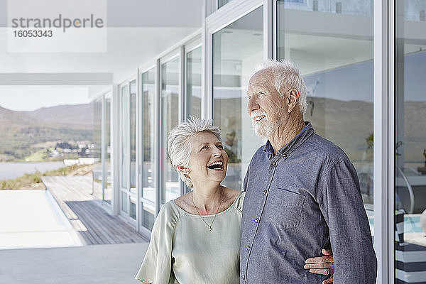 Glückliches Seniorenpaar in luxuriösem Strandhaus