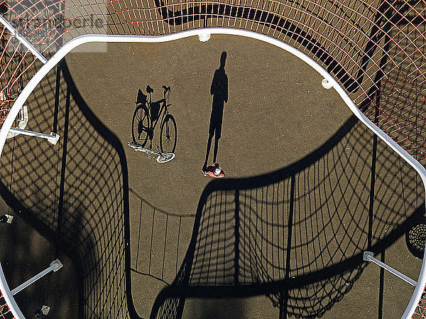 Mann mit Fahrrad auf Sportplatz,  Luftaufnahme