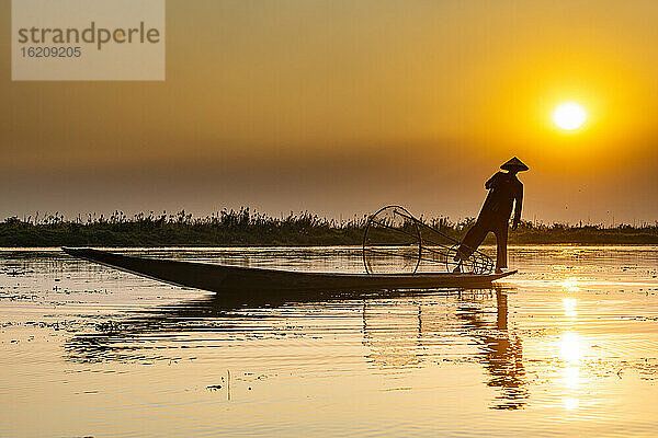 Myanmar,  Shan-Staat,  Silhouette eines traditionellen Intha-Fischers am Inle-See bei Sonnenuntergang