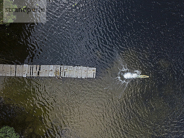 Luftaufnahme eines jungen Mannes beim Planschen im See