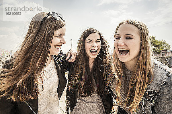Drei lachende Teenager-Freundinnen im Freien