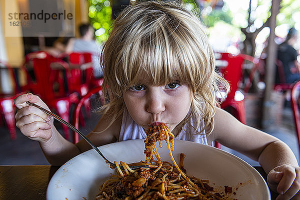 Mädchen isst Spaghetti im Restaurant