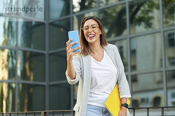 Fröhliche Geschäftsfrau nimmt Selfie durch Smartphone