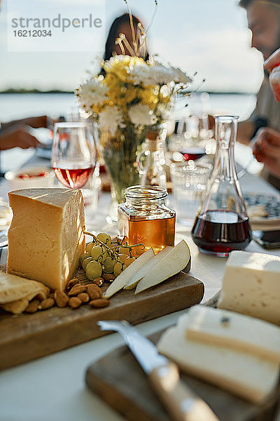 Käseplatte auf einem Tisch mit Menschen im Hintergrund