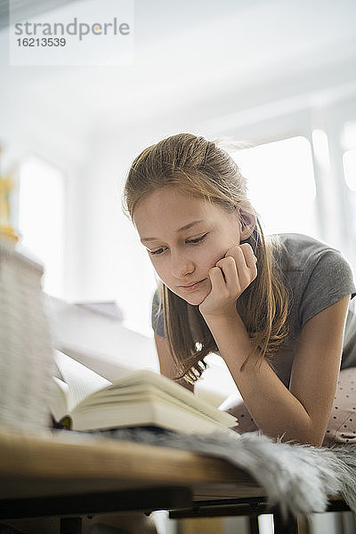 Mädchen liest ein Buch zu Hause