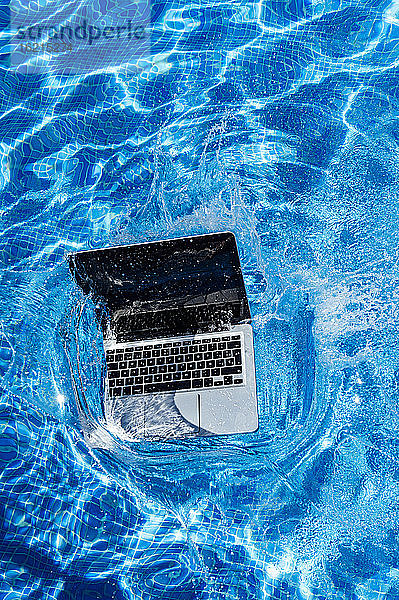Hohe Winkel Ansicht von Laptop fallen in Schwimmbad