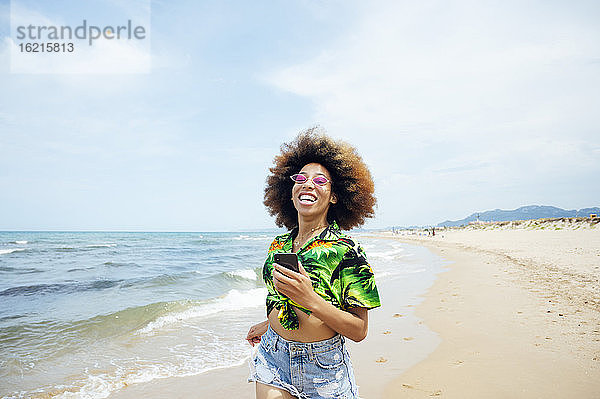 Glückliche junge Frau beim Laufen am Strand