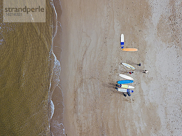 Luftaufnahme von Surfern bei der Vorbereitung auf den Sandstrand an der Küste