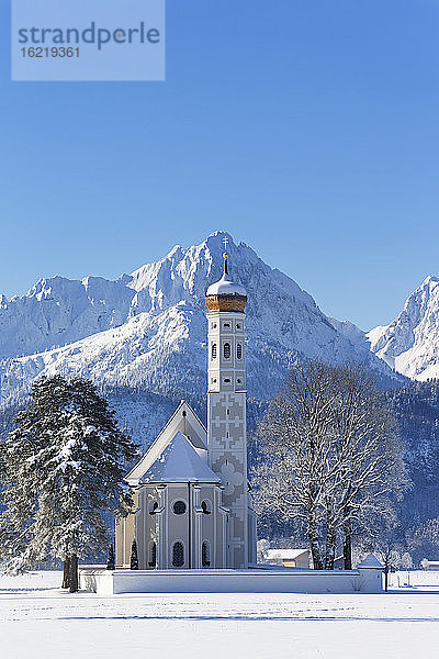 Deutschland,  Bayern,  Blick auf die Kirche St. Coloman vor den Tannheimer Bergen