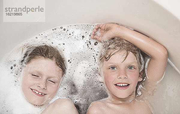 Österreich,  Junge und Mädchen entspannen sich in der Badewanne,  lächelnd