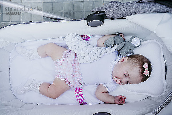 Schlafendes Mädchen im Kinderwagen