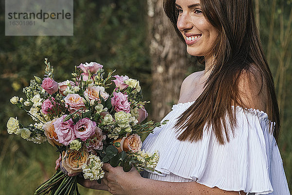 Lächelnde schöne Frau mit frischem Blumenstrauß