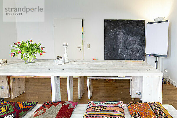 Raum mit Holztisch,  Kreidetafel und Projektionsfläche