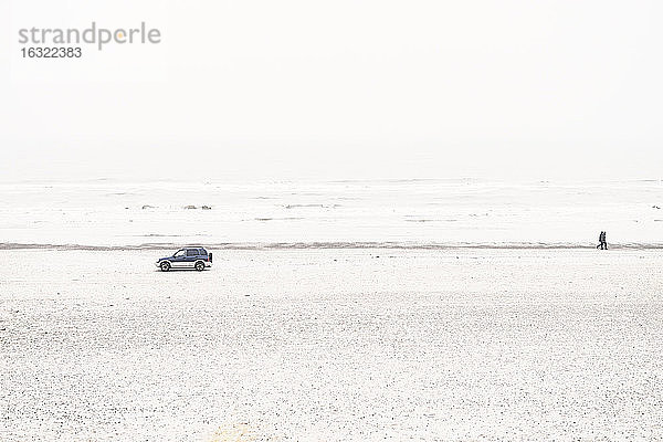 Dänemark,  Henne Strand,  Auto und spazierendes Paar am Strand