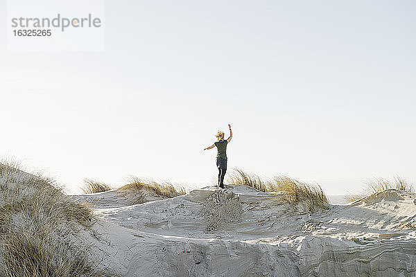 Dänemark,  Henne Strand,  Glückliche Frau auf Sanddüne stehend