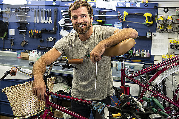 Mechaniker lehnt sich an Fahrrad