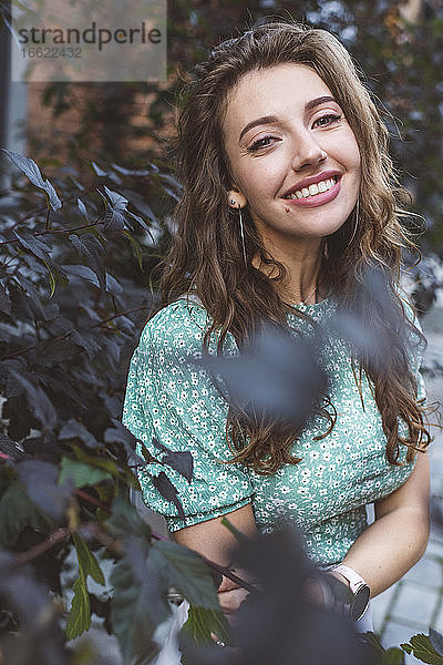 Lächelnde schöne Frau bei Pflanzen