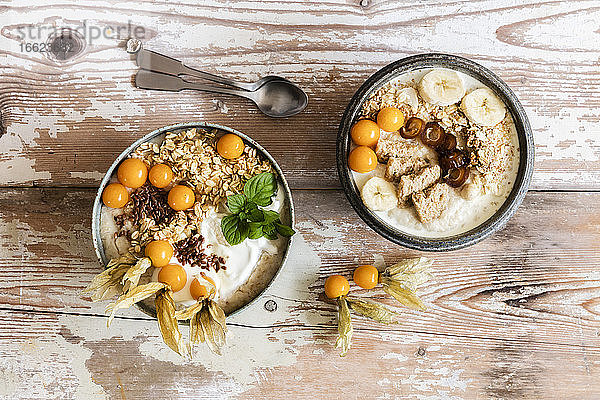 Zwei Schalen Porridge mit Haferflocken,  Leinsamen,  Winterkirschen und Bananen