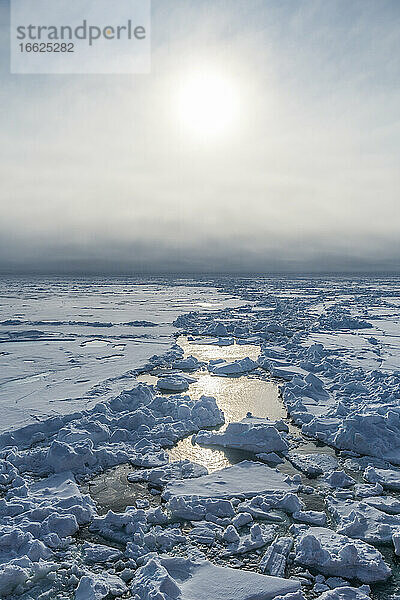 Die Sonne scheint über gebrochenem Eis im Arktischen Ozean