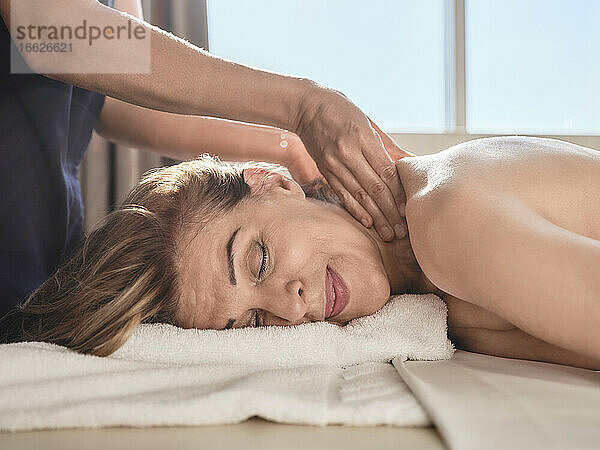 Midsection einer Frau bei der Massage einer älteren Frau im Spa