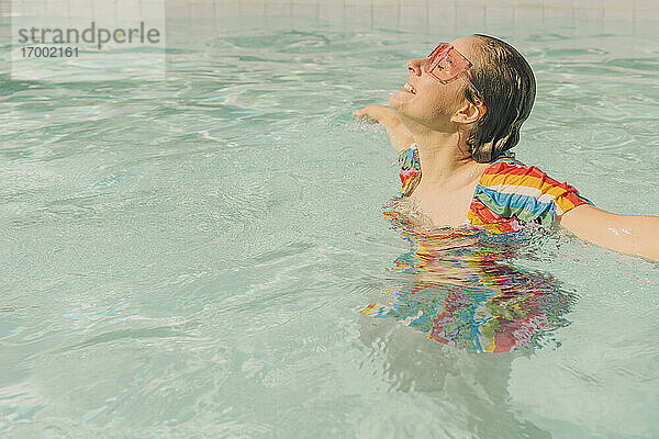 Bekleidete Frau entspannt sich im Schwimmbad