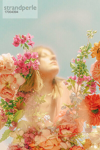 Schöne Frau mit Blumen hinter Glasscheibe