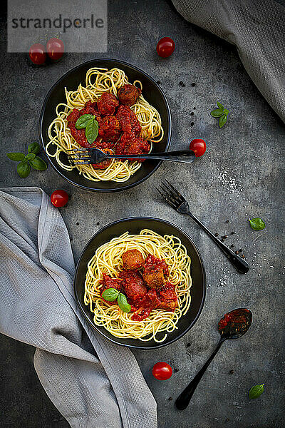 Zwei Schüsseln Spaghetti mit vegetarischer Polpette und Basilikum