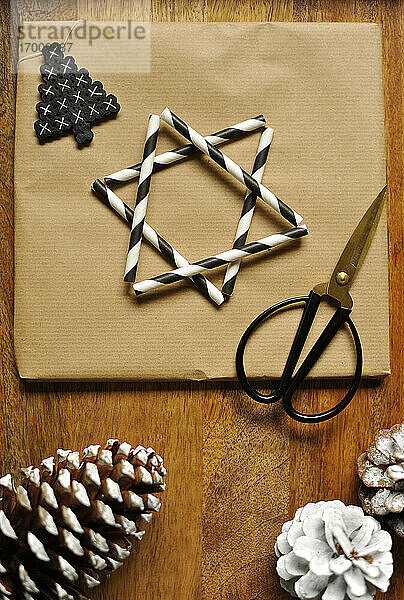 Geschenkpapier verziert mit einem Stern aus gestreiften Trinkhalmen