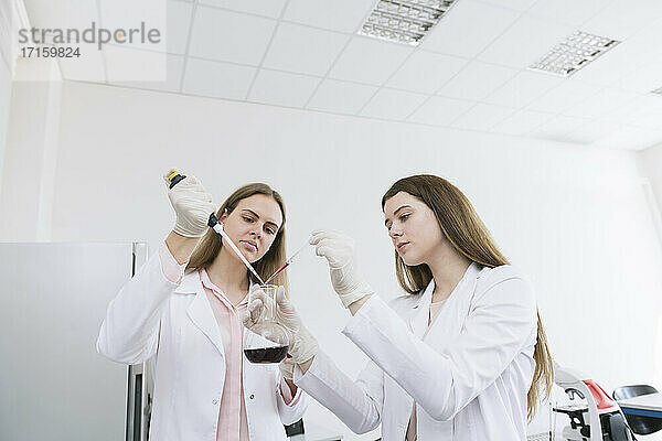 Wissenschaftler in weißen Kitteln beim Experimentieren im Labor