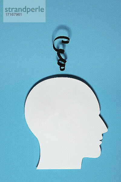 Papierausschnitt eines menschlichen Kopfes mit einem Stück Schnur,  das die Gedanken darstellt