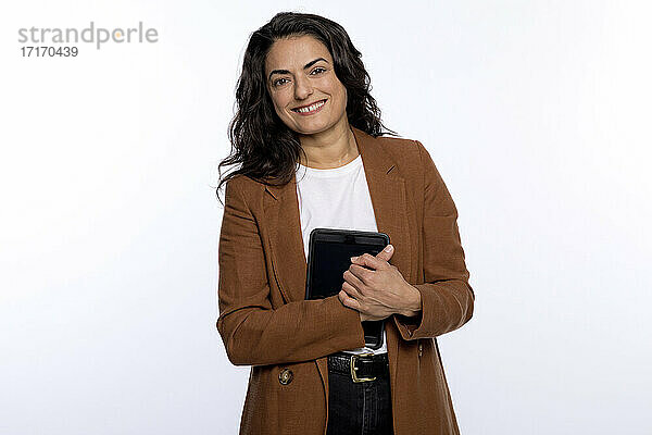 Glückliche Frau mit digitalem Tablet vor weißem Hintergrund