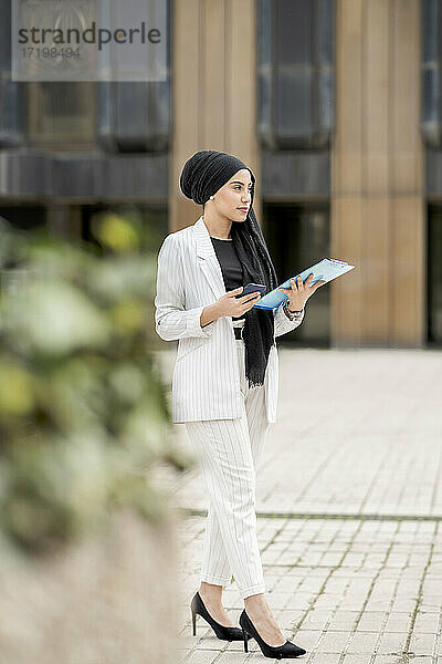 Schöne arabische Geschäftsfrau stehend im Freien