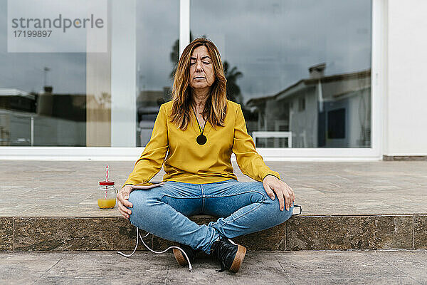 Frau meditiert im Freien sitzend