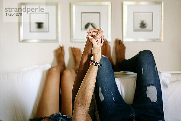 Ehemann und Ehefrau halten sich an den Händen,  während sie auf dem Bett liegen
