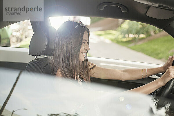Lächelnde glückliche Frau am Steuer eines Autos