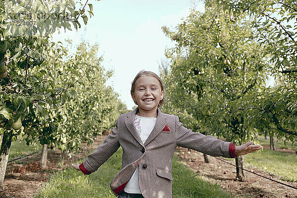 Fröhliches Mädchen läuft im Obstgarten
