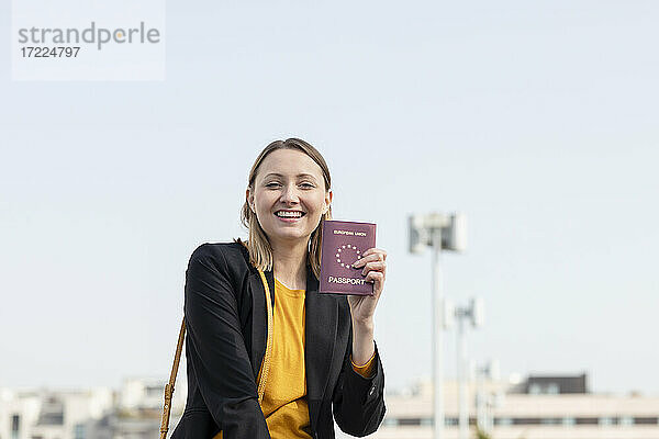 Fröhliche Geschäftsfrau zeigt Reisepass