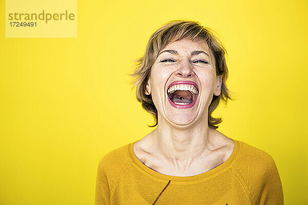 Frau lachend vor gelbem Hintergrund