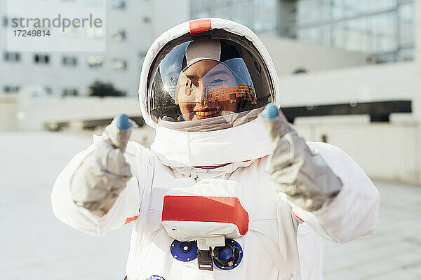 Glückliche Astronautin im Raumanzug gestikuliert im Freien