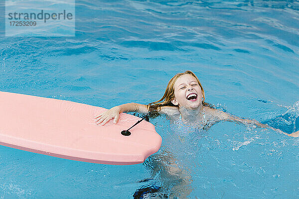 Fröhliches Mädchen spielt im Schwimmbad