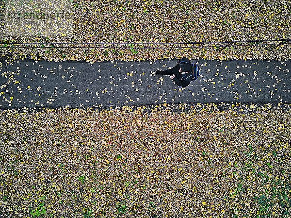 Luftaufnahme eines Mannes bei einem Spaziergang im Herbstpark
