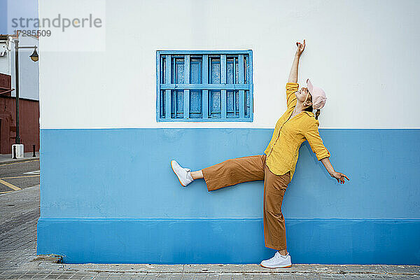 Fröhliche Frau tanzt an der Wand