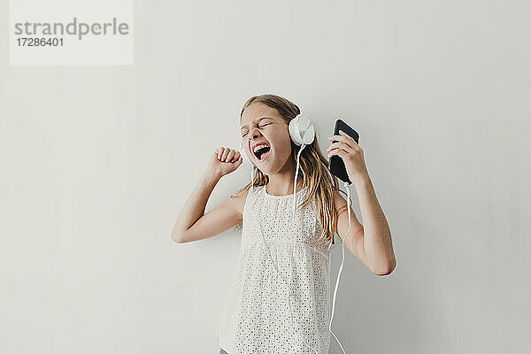 Glückliches Mädchen hört Musik über Kopfhörer