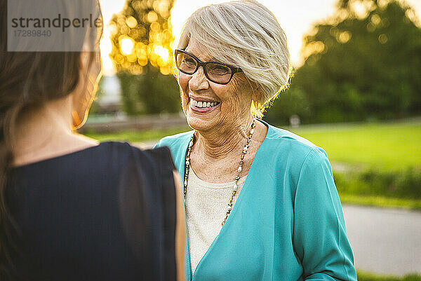 Glückliche Großmutter betrachtet ihre Enkelin im Park
