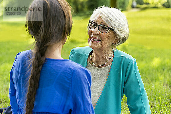 Ältere Frau im Gespräch mit mittelalterlicher Frau in einem öffentlichen Park