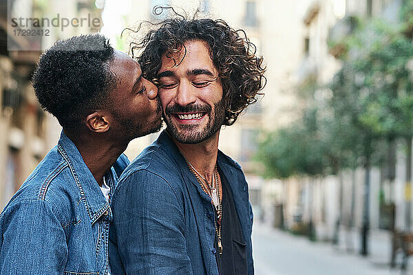Zärtlicher schwuler Mann küsst glücklichen Freund