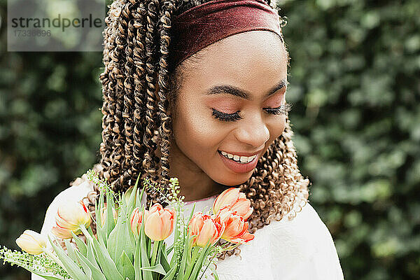 Schöne lächelnde junge Frau mit Blumen